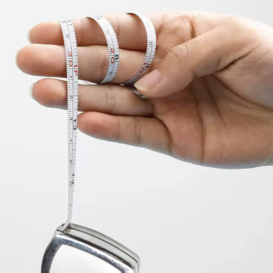 mètre à ruban enroulé autour de main de femme